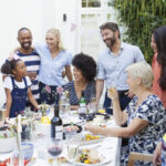 People of all ages gathered around the table eating.