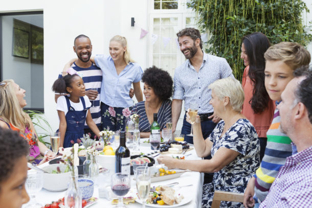 People of all ages gathered around the table eating.